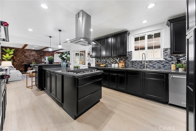 kitchen featuring a kitchen island, pendant lighting, island range hood, sink, and stainless steel appliances