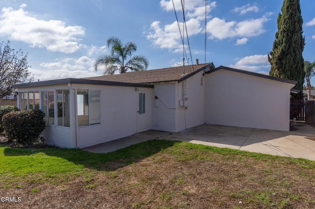 rear view of property featuring a lawn and a patio area