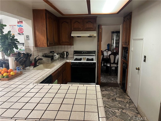 kitchen featuring range hood, tasteful backsplash, sink, tile counters, and gas range oven