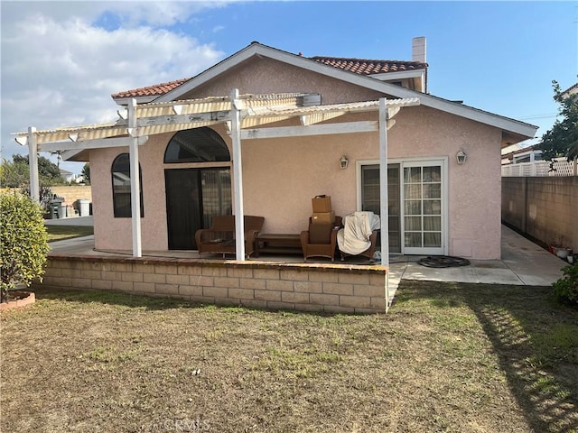 back of property featuring a patio, a pergola, and a lawn