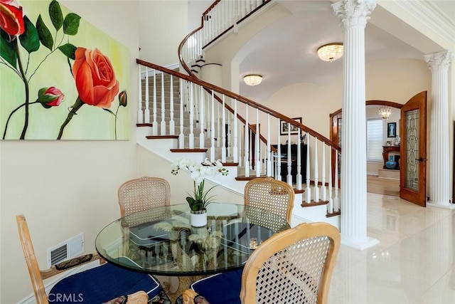 dining space featuring decorative columns, visible vents, a high ceiling, baseboards, and stairs