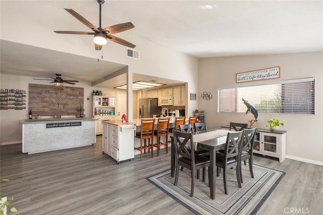 dining space featuring dark wood-type flooring, ceiling fan, and lofted ceiling