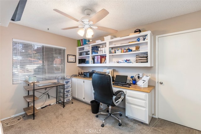 carpeted office with ceiling fan and a textured ceiling