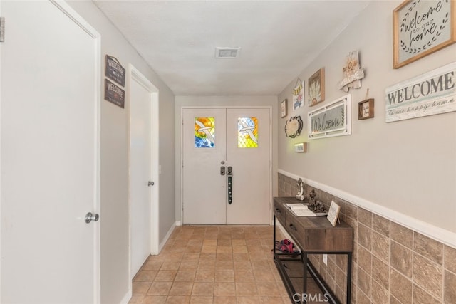 doorway featuring french doors and tile walls