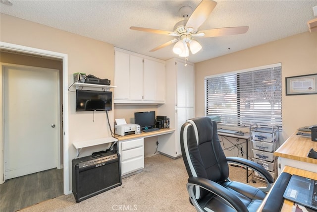 carpeted office with ceiling fan and a textured ceiling