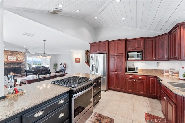 kitchen featuring vaulted ceiling, a fireplace, light stone counters, wood ceiling, and stainless steel appliances