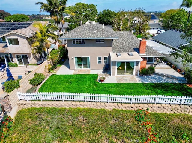 rear view of house featuring a lawn and a patio area