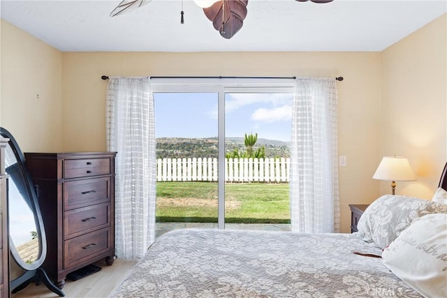 bedroom featuring access to exterior, ceiling fan, and light hardwood / wood-style flooring