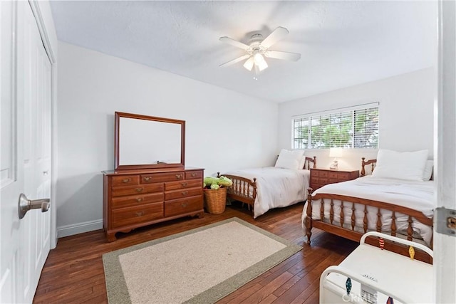 bedroom with dark hardwood / wood-style flooring, a closet, and ceiling fan