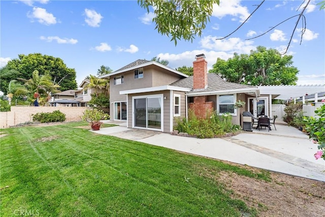 rear view of house featuring a patio and a lawn