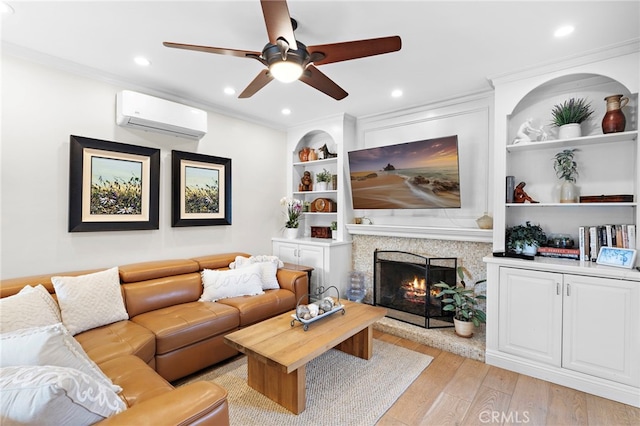 living room with ornamental molding, a wall mounted AC, built in features, and light hardwood / wood-style floors