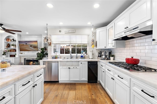 kitchen featuring appliances with stainless steel finishes, tasteful backsplash, white cabinetry, ceiling fan, and light hardwood / wood-style flooring