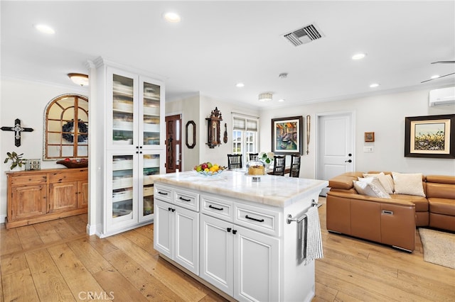 kitchen featuring white cabinetry, a kitchen island, and light hardwood / wood-style floors