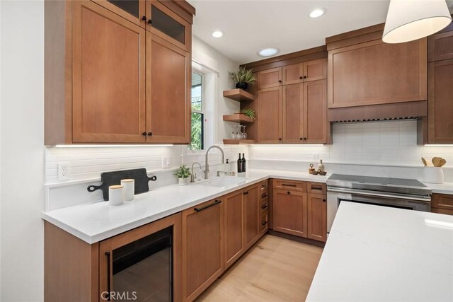 kitchen featuring electric stove, sink, decorative backsplash, and light stone countertops