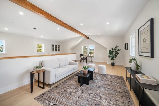 living room with vaulted ceiling with beams and light wood-type flooring