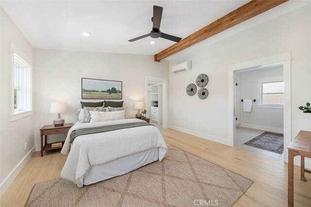 bedroom with a wall mounted air conditioner, vaulted ceiling with beams, ceiling fan, and light wood-type flooring