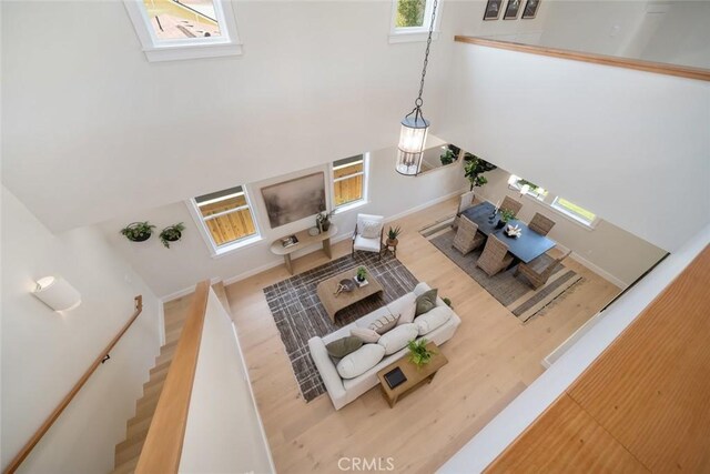 living room featuring hardwood / wood-style flooring and a towering ceiling