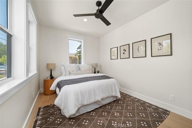 bedroom with dark hardwood / wood-style flooring and ceiling fan