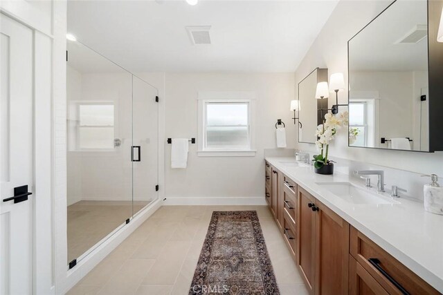 bathroom featuring a shower with door, vanity, plenty of natural light, and tile patterned flooring