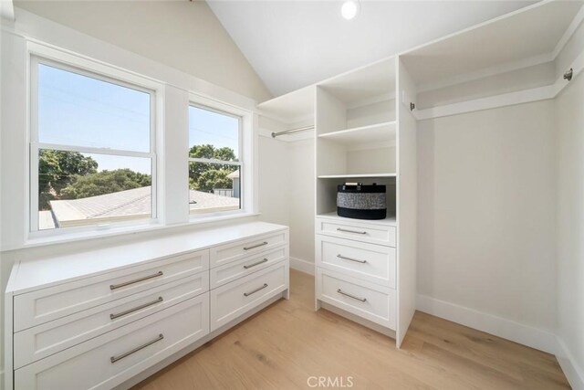 spacious closet featuring vaulted ceiling and light hardwood / wood-style floors