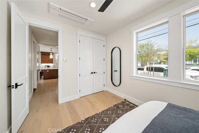 bedroom featuring hardwood / wood-style flooring, ceiling fan, and a closet