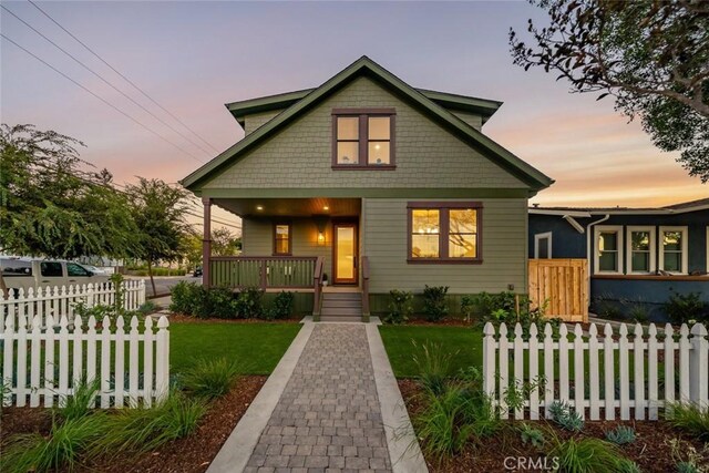 bungalow featuring a porch and a yard