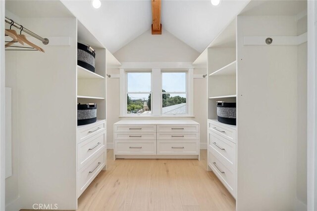 walk in closet with vaulted ceiling with beams and light hardwood / wood-style flooring