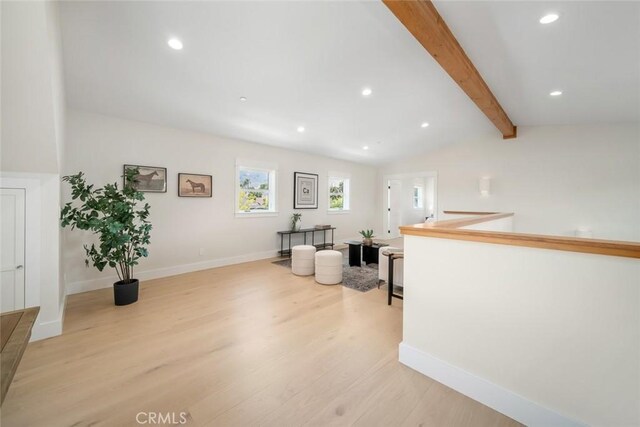 interior space with light hardwood / wood-style floors and vaulted ceiling with beams