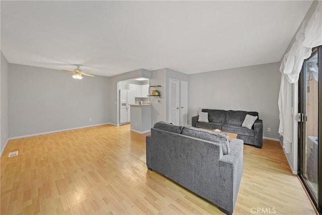 living room featuring ceiling fan and light hardwood / wood-style flooring