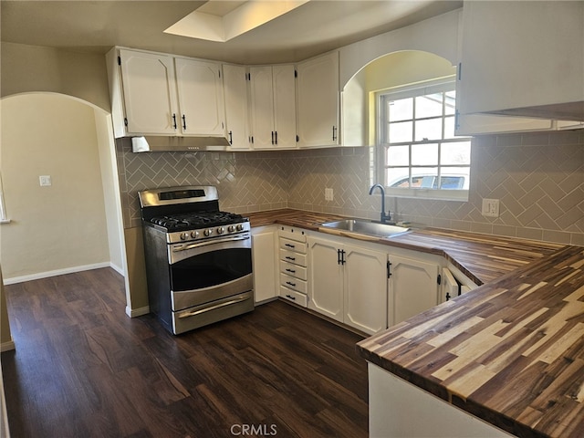 kitchen with butcher block counters, white cabinetry, a sink, and gas stove