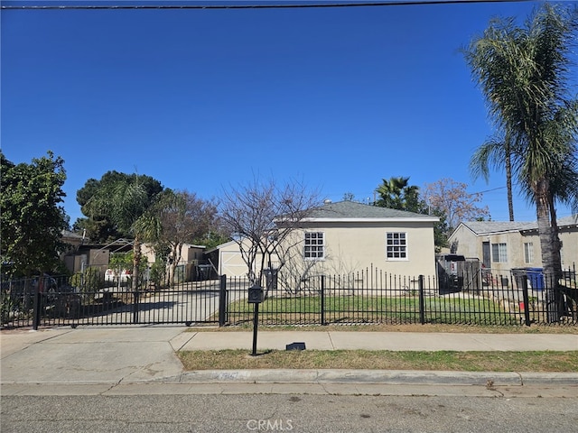 bungalow-style house featuring a fenced front yard, a residential view, concrete driveway, and stucco siding