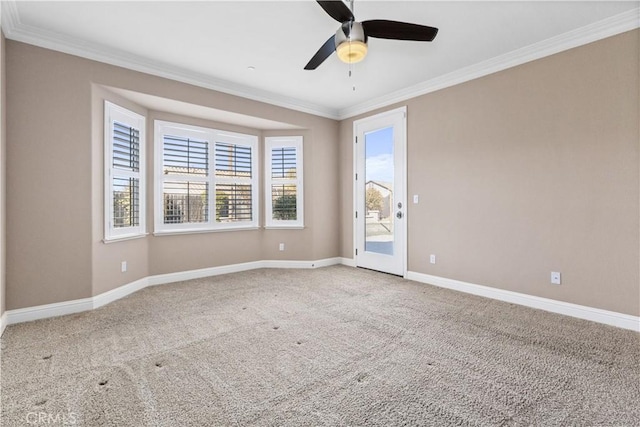 carpeted empty room featuring crown molding and ceiling fan