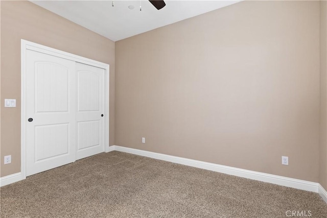 unfurnished bedroom featuring carpet, ceiling fan, and a closet