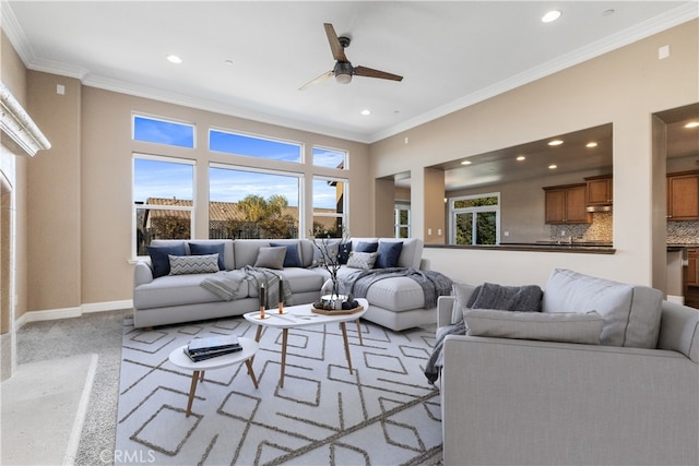 living room with ornamental molding, plenty of natural light, and ceiling fan