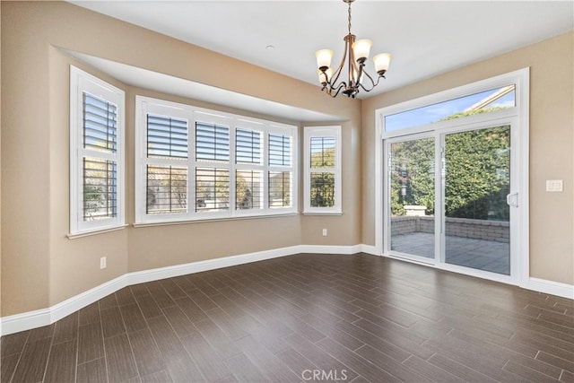 spare room featuring dark hardwood / wood-style flooring and a notable chandelier