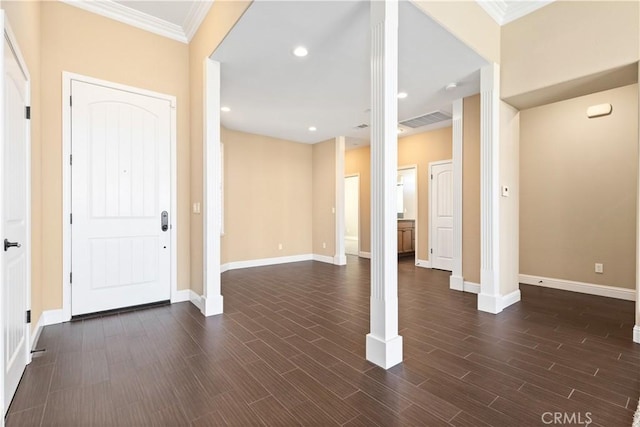 foyer featuring ornate columns, crown molding, and dark wood-type flooring