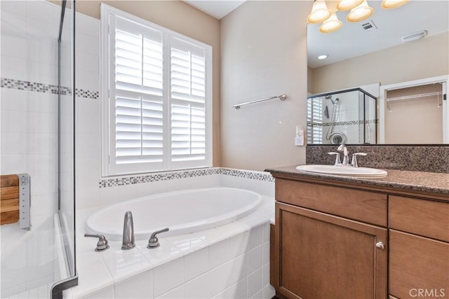 bathroom featuring vanity and shower with separate bathtub