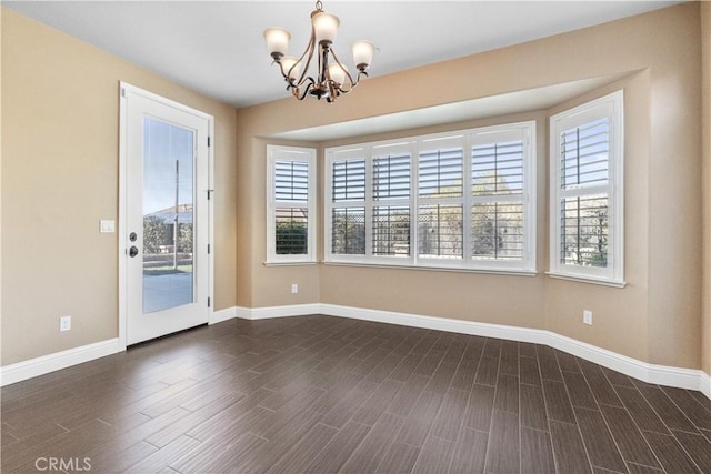 spare room featuring dark hardwood / wood-style floors and a chandelier