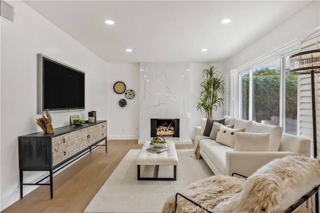 living room featuring a fireplace and light hardwood / wood-style flooring