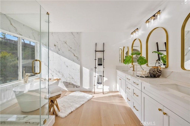 bathroom with hardwood / wood-style floors, vanity, and a washtub