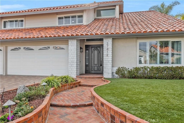 mediterranean / spanish-style house featuring a garage and a front lawn