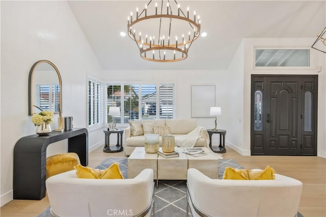 living room with high vaulted ceiling, hardwood / wood-style floors, and a notable chandelier