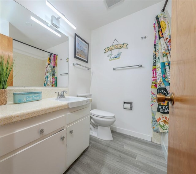 bathroom featuring hardwood / wood-style flooring, vanity, and toilet