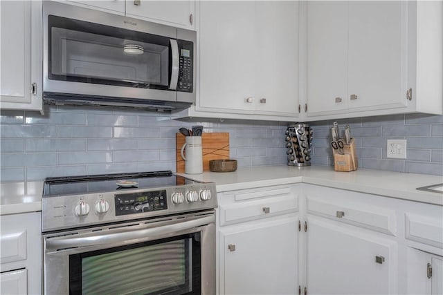 kitchen featuring appliances with stainless steel finishes, white cabinets, and backsplash