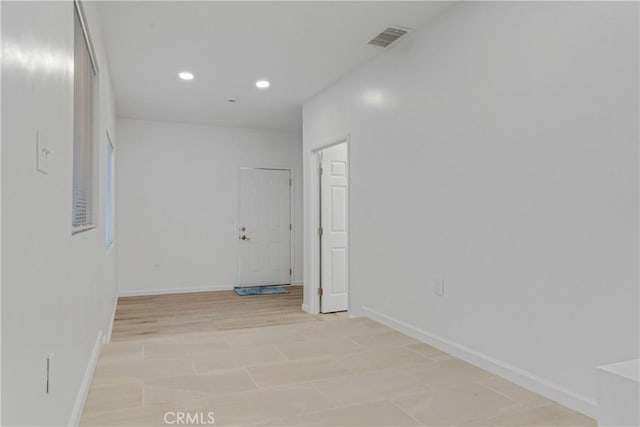 empty room featuring baseboards, visible vents, and recessed lighting