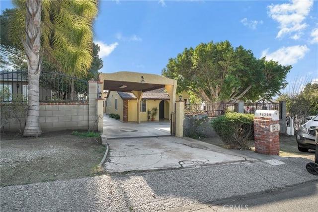 view of front of property with a gate, fence, and stucco siding