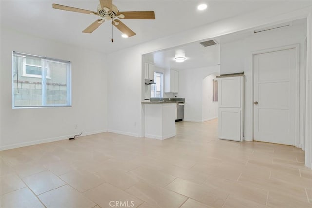 unfurnished living room with baseboards, visible vents, arched walkways, a ceiling fan, and recessed lighting