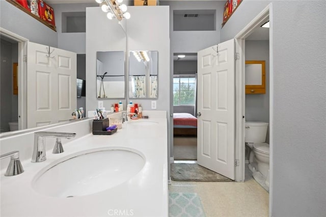 bathroom featuring vanity, toilet, and a chandelier