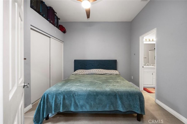 carpeted bedroom featuring a closet, ceiling fan, and ensuite bathroom