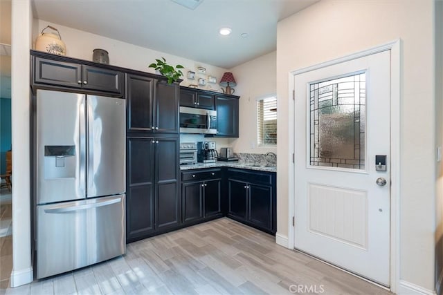 315 Timberline Way S, Madera, CA 93636 - kitchen with appliances with stainless steel finishes, a sink, light stone counters, light wood finished floors, and recessed lighting